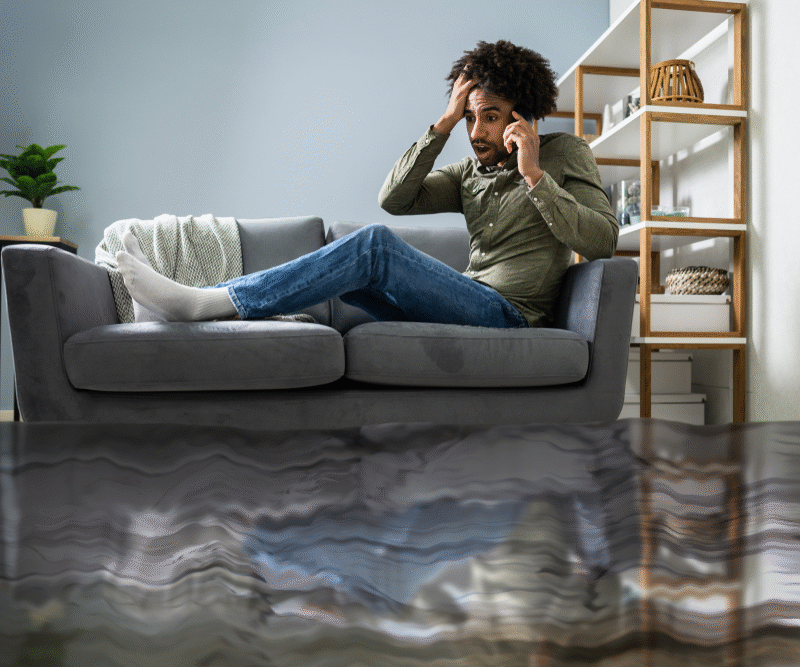 man sitting on flooded living room couch