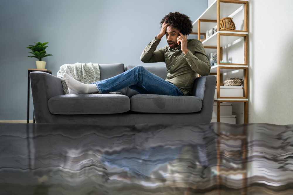 man sitting on flooded living room couch